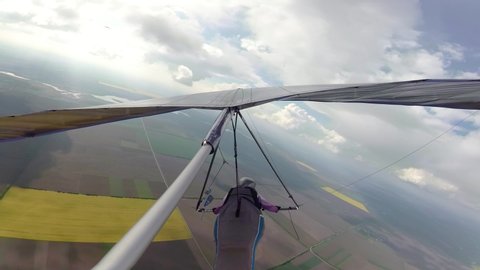 Hang glider pilot race between clouds on high altitude. Beauty of extreme sport