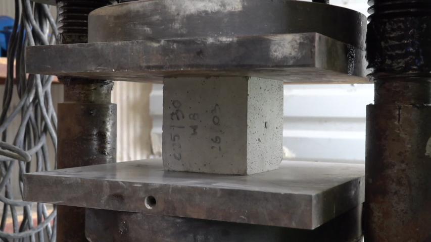 Concrete block breaks under high pressure. Hydraulic press is creating pressure on cube made of concrete. Strength test. Breaking point of hardness test. Royalty-Free Stock Footage #1029827558