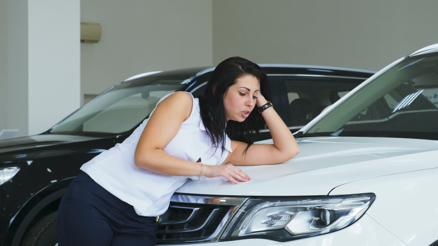 Girl lies on a new car and Stoke on hood