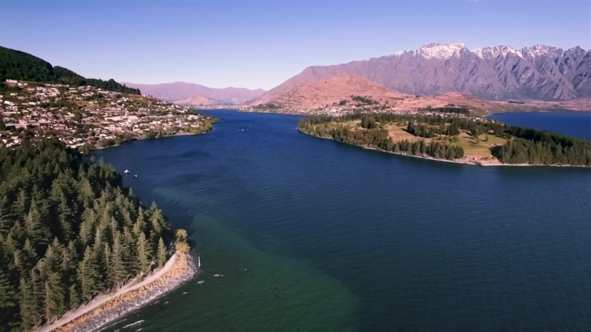 Aerial view of Queenstown on the bank of Lake Wakatipu with The Remarkables mountain range in the background. Major tourist destination in New Zealand. Royalty-Free Stock Footage #1029829730