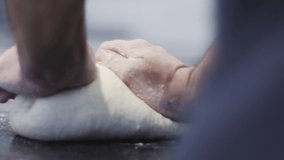 Hands prepare the dough on the background of fire. Chef preparing the pizza dough in slow motion. Food video.