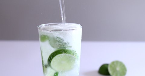 Close up of pouring sparkling water to make Mojito Cocktail