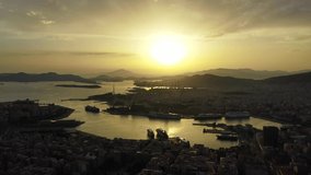 Aerial drone bird's eye view video of famous port of Piraeus one of the largest in Europe at sunset with beautiful golden colours, Attica, Greece