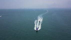 Low aerial view of two speed boats passing underneath the camera en-route to an exotic island from the mainland - Tourist boats rushing past with passengers to a tropical island resort 4k