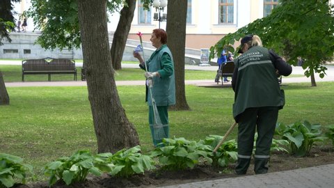 GOMEL, BELARUS - MAY 15, 2019: Palace and park ensemble Paskevichi. Women spud plants on the lawn.