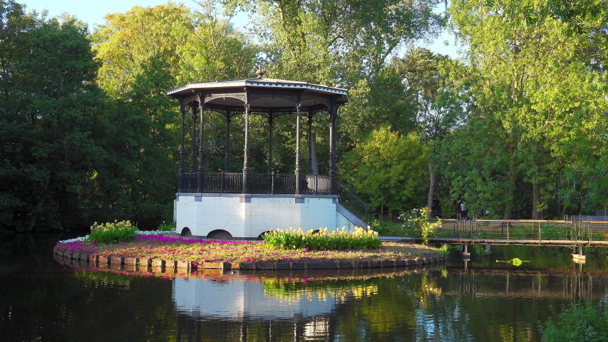 Still shot a gazebo in Vondelpark, calm, mirroring pond, on a warm summer day, in Amsterdam, Netherlands