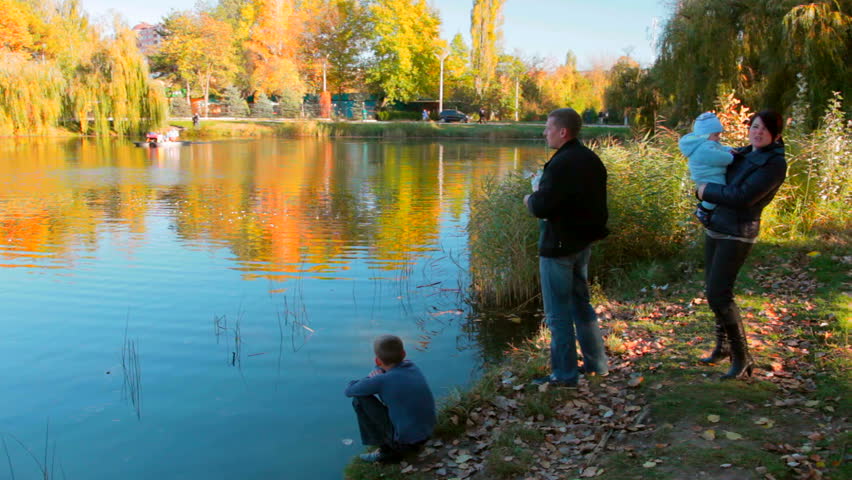 family in a park near a pond