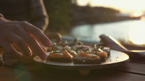 Salmon and cream cheese on bread. Picnic food by the beach. Beautiful sunset light