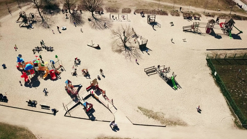 Playground aerial shot. Children playing. Public playground in Ronald Reagan Park, Gdansk, Poland. Flying sideways. Spring 2019