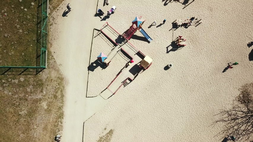 Playground aerial shot. Children playing. Public playground in Ronald Reagan Park, Gdansk, Poland. Flying forward, looking straight down. Spring 2019