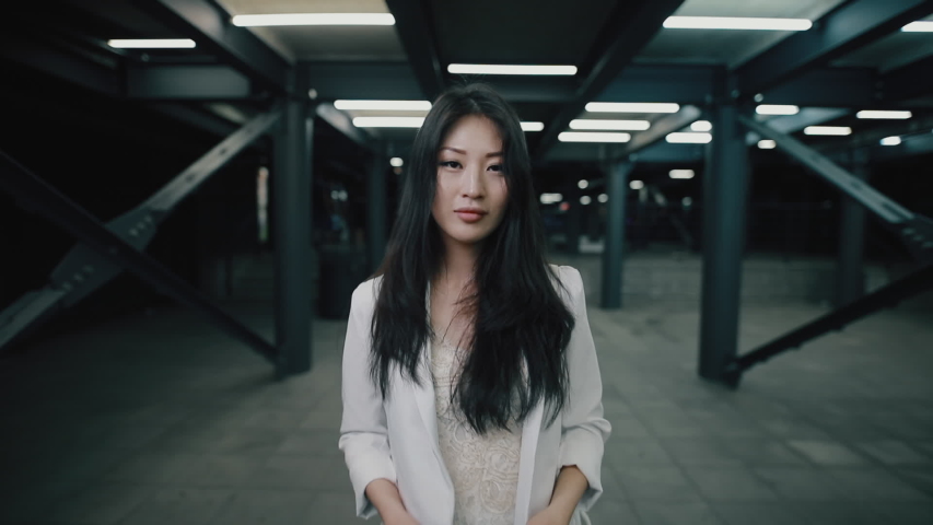 Asian woman puts on headphone walking at night underground Royalty-Free Stock Footage #1029905129