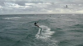 Close up aerial video of kiteboarder doing big trick off a wave