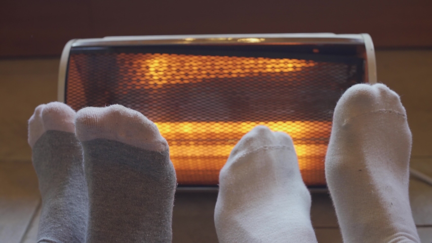 Two pairs of feet play and move joyfully next to a small warm radiator Royalty-Free Stock Footage #1029921443