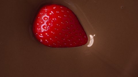 Macro video of the ripe strawberry, that drowns in the melted chocolate in slow motion, making of the natural sweets, making of sweet desserts, 4k UHD Prores 422 HQ 60p