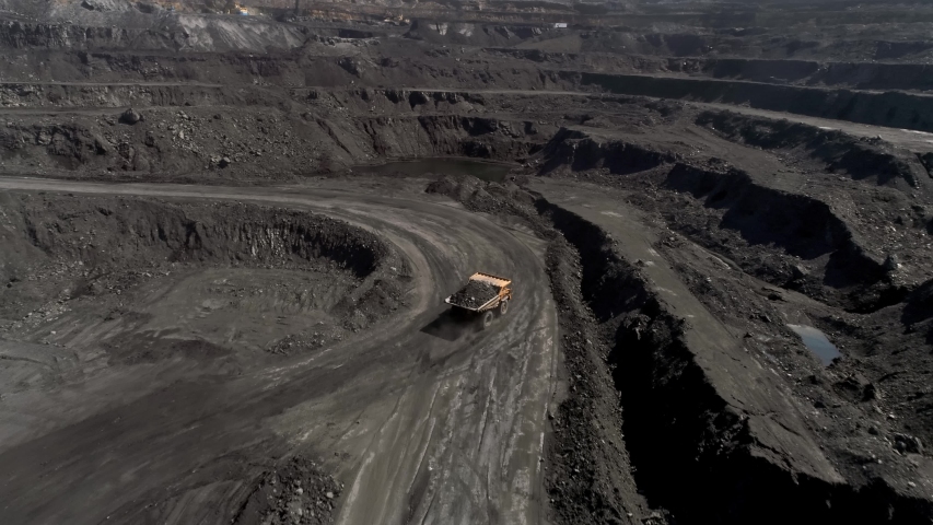 Panorama aerial view shot open pit mine coal mining, dumpers, quarrying extractive industry stripping work. Big Yellow Mining Trucks. View from drone at opencast mining with lots of machinery trucks | Shutterstock HD Video #1029938138
