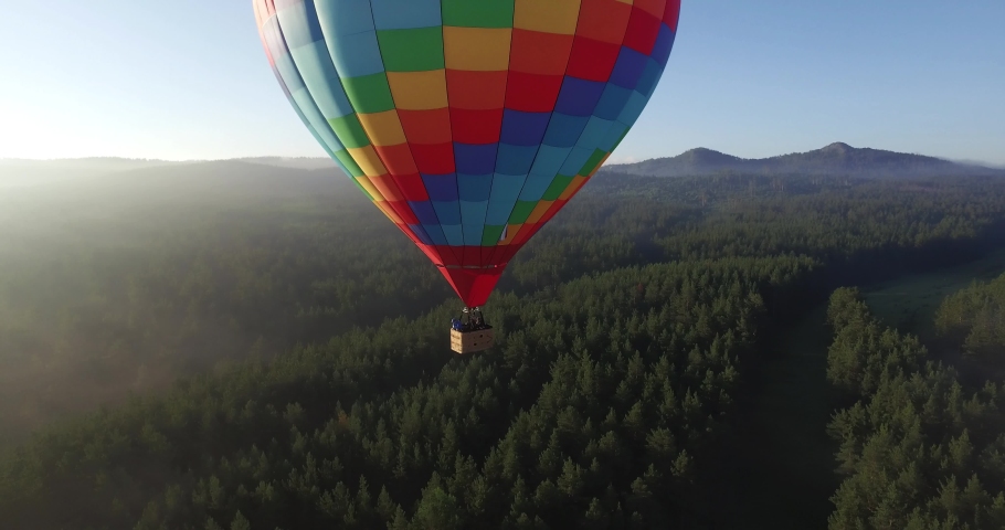 Colorful hot air balloon epic flying above mountain over the fog at sunrise with beautiful sky background - Aerial drone view Royalty-Free Stock Footage #1029942356