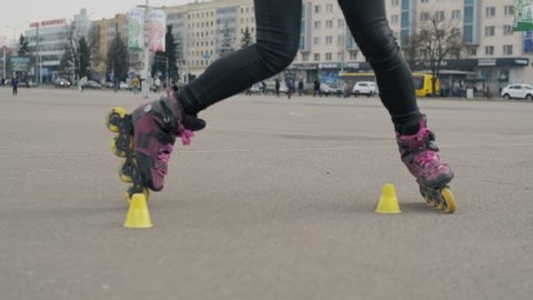 Close up of woman rides on roller skates and whirl in slow motion. Young woman on roller skates 库存视频