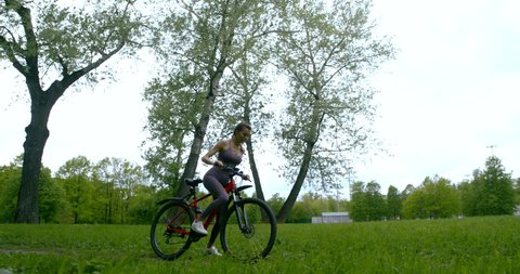 Cycling in the open air. A young woman riding a Bicycle on a country road.