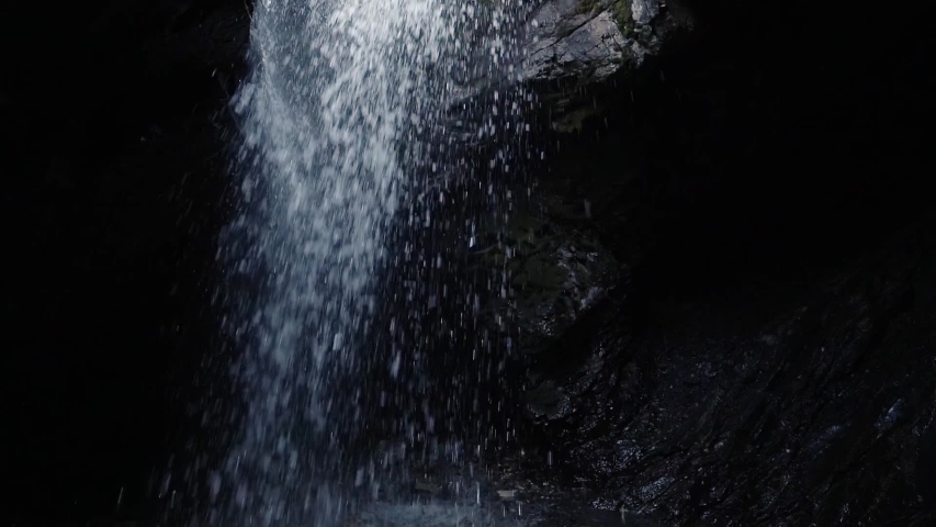 Water falling through a hole into a cave at donut falls in Big Cottonwood Canyon, Utah.