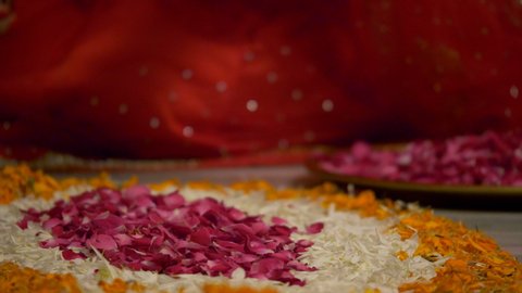 Diwali decoration - Indian women making flower rangoli with rose petals .