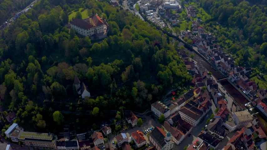Aerial round pan from high above to the right of the Castle and city of Neuenbürg in the black forest.