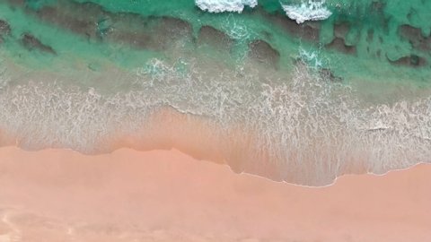 Aerial shot of white sand beach and turquoise ocean water in Oman, near Salalah. Arabian Peninsula