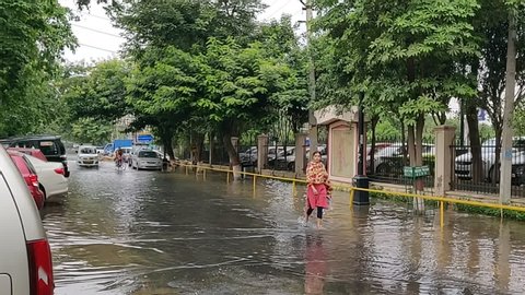 Gurgaon, Haryana, India 05/22/2019 - Car and people crossing sewage water. Untreated sewage being discharged from a sanitary sewer. Spilling on the roads in residential area.