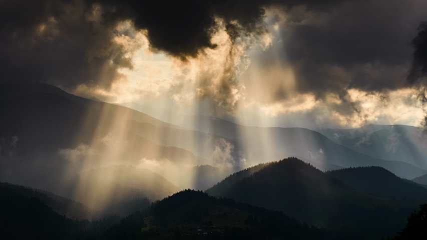 Timelapse of sun rays emerging though the dark storm clouds in the mountains  | Shutterstock HD Video #1029971897