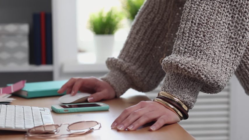 Young trendy hipster woman dances cheerfully in her home office. It