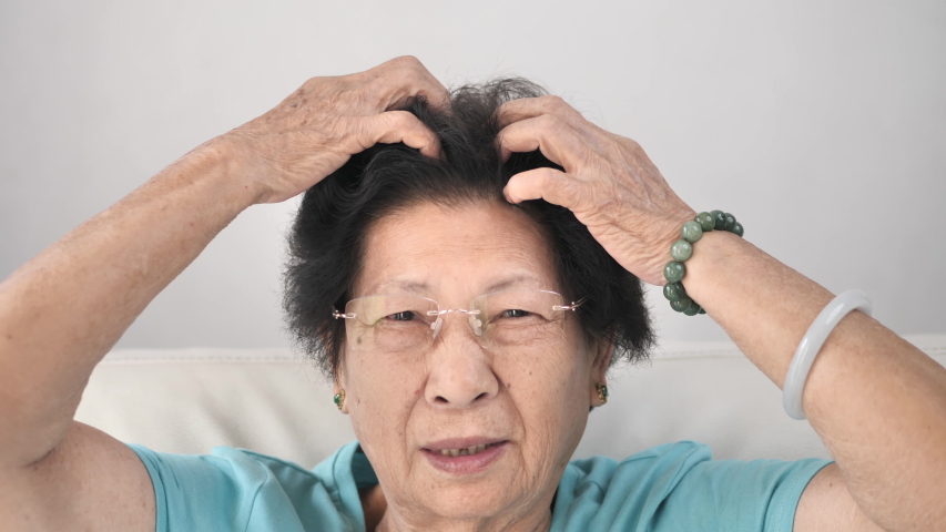 Asian senior woman scratching her head, lifestyle concept and slow motion.