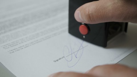 Notary public in office stamping document. Businessman stamping document table, director approving contract, paperwork. Man is approve documents by signing and stamping papers. Closeup. UHD 4K.