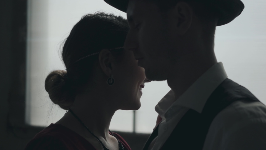 Portrait man in fedora hat, classical suits and woman in style cloth dancing in dirty place.