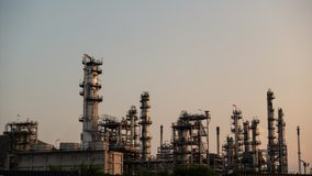 Timelapse view of a oil refinery silhouetted against the sunset at dusk