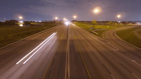 Traffic Speeds North and South on the Florida Turnpike in a Time-Lapse at Sample Road in Pompano Beach from the Overpass Bridge at Night with Some Vehicles Curving to the Right on the Off-Ramp