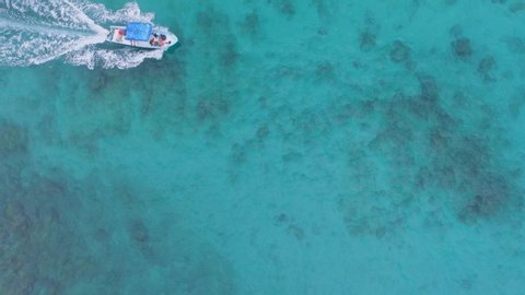 Aerial cenital shot of a panga boat and a tourist swimming in the Marietas Islands, Nayarit, Mexico