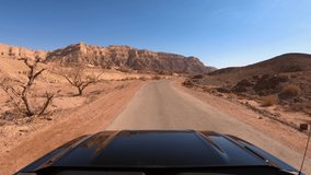 Driving footage onboard a Black Pickup truck on an off road Desert path, wide angle view on a clear sunny day with lens flare.