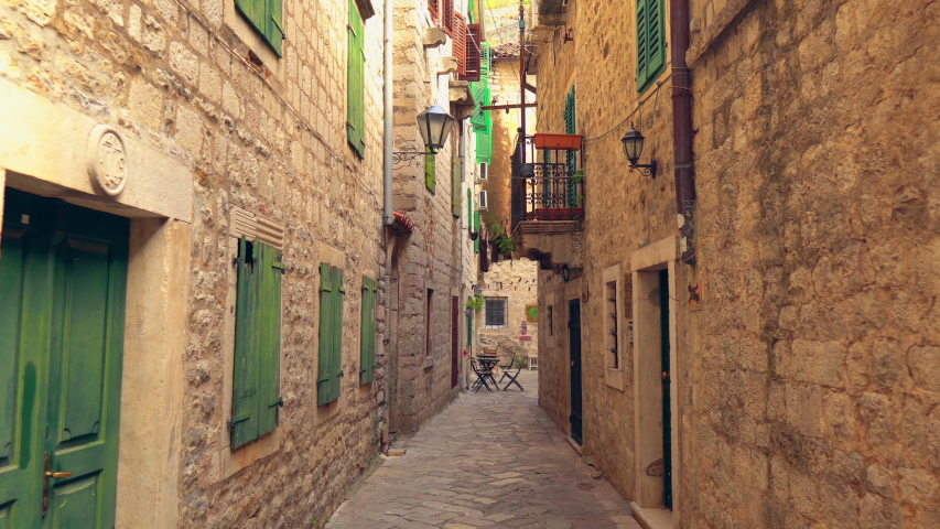 Narrow Passage In Montenegro. Daylight. Green Wooden Windows And Doors.