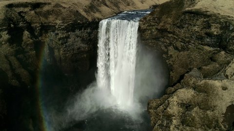 Flying near Skogafoss Waterfall in the South of Iceland. Aerial shot of high water cascades and a colorful rainbow apperance. 库存视频