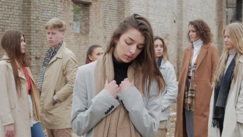A beautiful young woman is upset among a group of young people on the ruins. The youth makes a theater etude amid a collapsed brick building Royalty-Free Stock Footage #1030015670