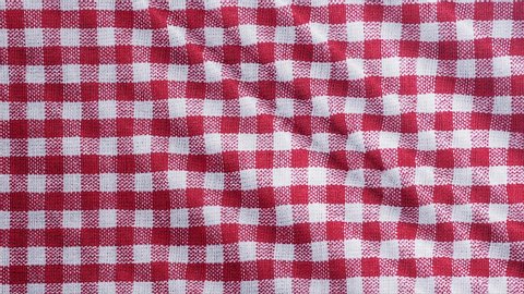 Red white tablecloth, picnic gingham is waving. Top view checkered fabric cloth background.