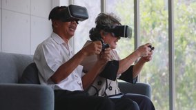 Slow motion scene video of senior Asian couple using VR device which are fun virtual computer or video games.
