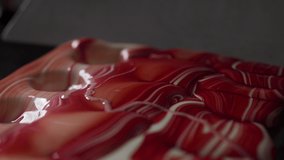 Food macro video with texture of melted white colored chocolate on the candys' molds, melted liquid chocolate, making of pastry sweets by chocolatier, 4k UHD 60p Prores HQ 422