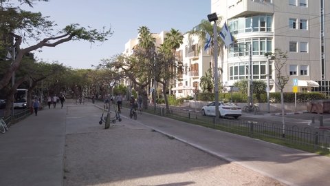 Tel Aviv - May 15th 2019: HyperLapse moving up Rothschild Boulevard, in the shade of the Avenue trees, between pedestrians, bicycles and rental scooters.