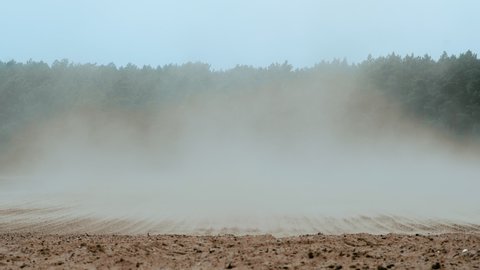 Dust clouds created by strong winds sweeping soil off a field, altering the increase of erosion rates due to unsustainable agricultural practices in Germany.
