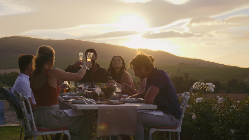Group of friends making a toast together outdoors. Young people having fun at a dinner party, raising a celebratory toast with champagne.
 | Shutterstock HD Video #1030033661