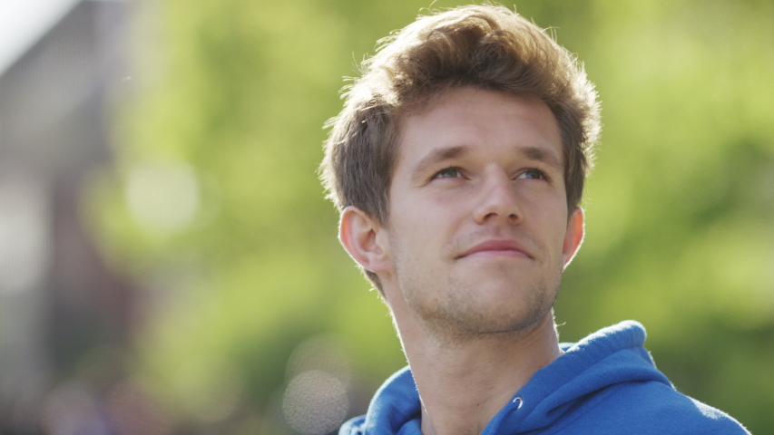 Portrait of confident male looking and smiling to camera, in slow motion 
