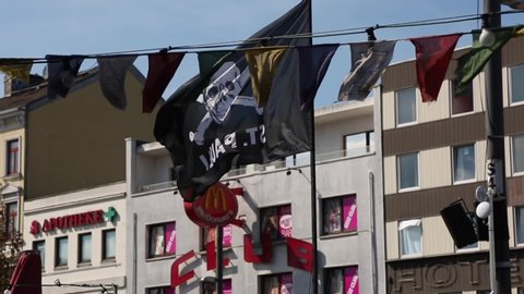 Hamburg, Germany - april.2017 Street festivities in Hamburg, Germany. flags, fluttering by the wind, lanterns. Black flag with a skull and bones fluttering in the wind. Houses on the background.