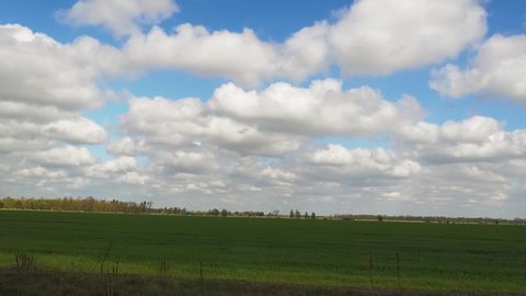 Germany. Shooting in motion from the window of a traveling car. Fields, bushes, trees, pointers, blue sky with clouds.