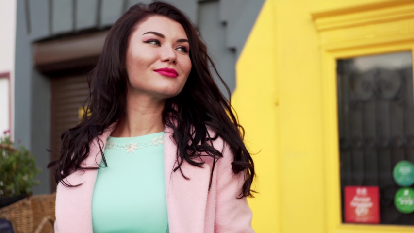 Portrait of young brunette woman with bright makeup looking into the camera and smiling