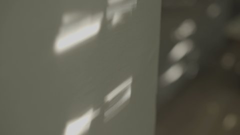 Sun and window createsing shadows on a wall in the morning light